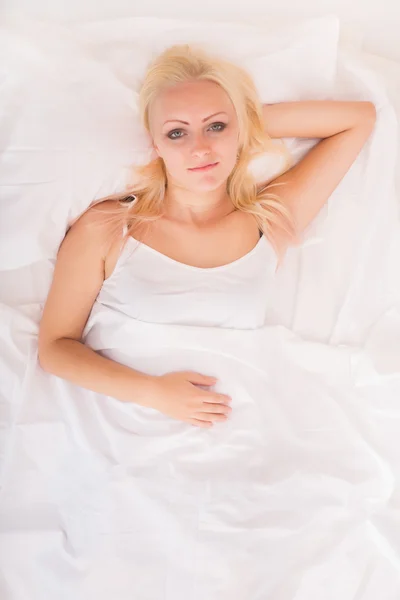 Blond meisje liggend in bed — Stockfoto