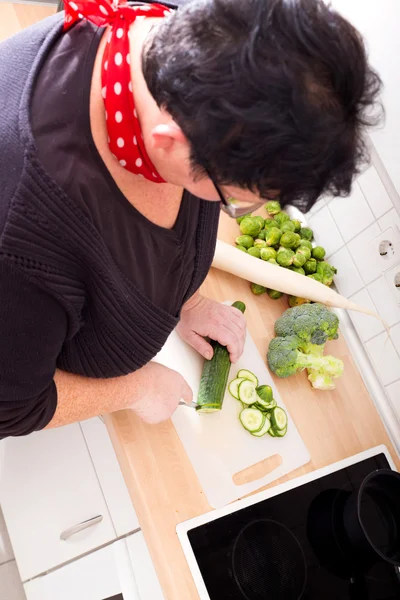 Femme coupant des légumes — Photo