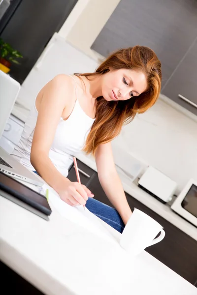 Roodharige meisje werken in keuken — Stockfoto