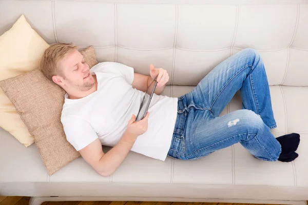 Jongeman die thuis een tablet gebruikt — Stockfoto