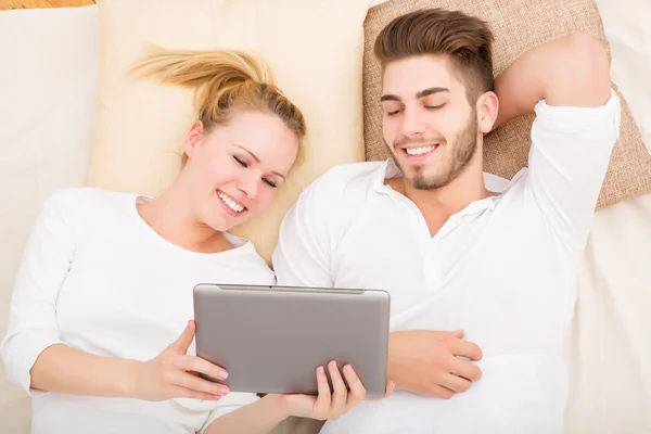 Mladý pár s tablet pc v posteli — Stock fotografie