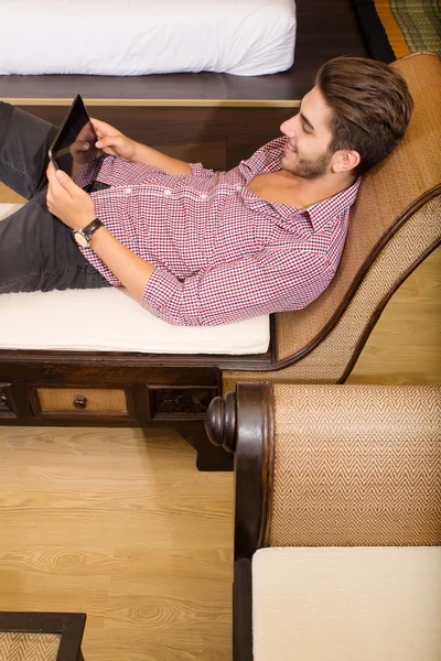 Jovem usando um tablet pc em um quarto de hotel asiático — Fotografia de Stock