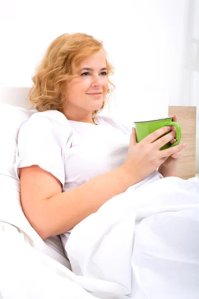 Jonge vrouw drinken koffie in bed — Stockfoto