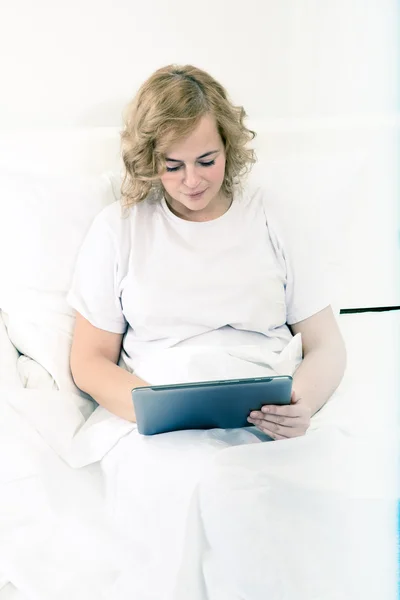 年轻的女人在床上使用 Tablet Pc — 图库照片