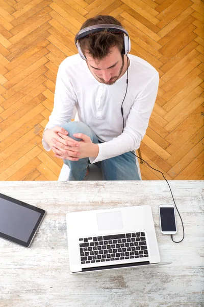 Ung man lyssnar musik på hans Laptop — Stockfoto