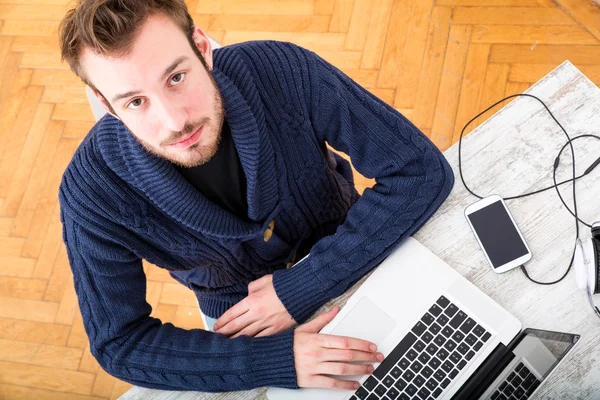 Młody człowiek pracuje w trybie online w domowym biurze — Zdjęcie stockowe