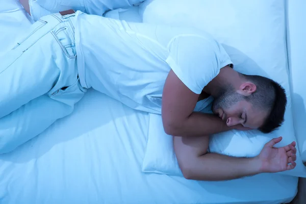 Junger Mann mit im Bett in der Nacht — Stockfoto