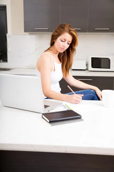 Roodharige meisje werken in keuken — Stockfoto