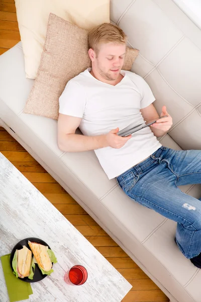 Giovane utilizzando un tablet a casa — Foto Stock