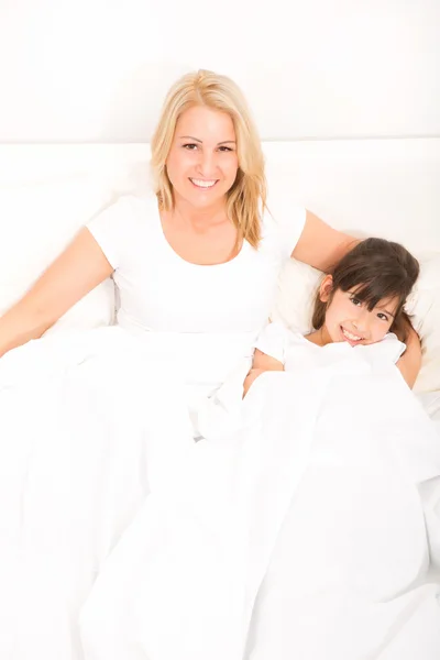 Madre con hija relajándose en la cama — Foto de Stock