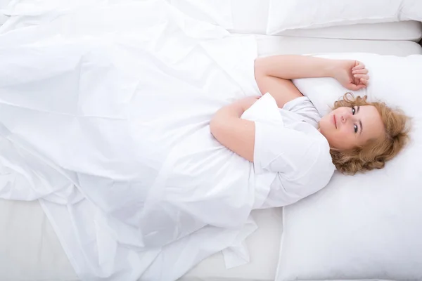 Молода жінка розслабляється в ліжку — стокове фото
