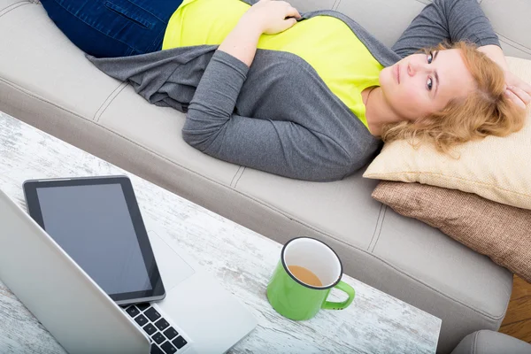 Young woman on the sofa with Gadgets — Stock Photo, Image