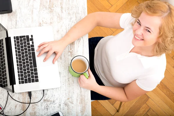 Joven mujer de tamaño grande trabajando en un ordenador portátil — Foto de Stock