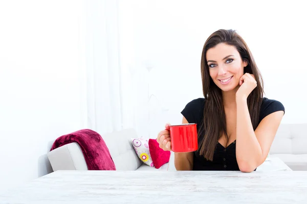 Молодая красивая женщина пьет кофе дома — стоковое фото