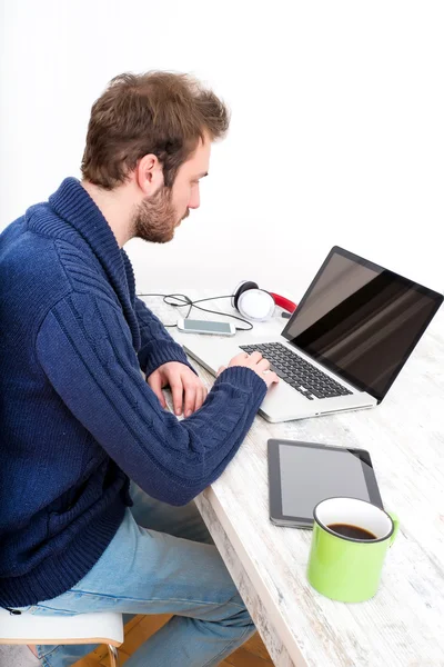 Ung mann som bruker PC-en hjemme – stockfoto