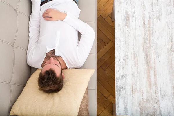 Jonge man ontspannen op de sofa — Stockfoto