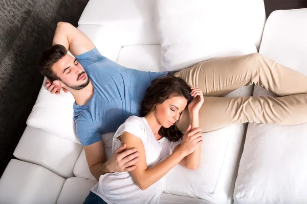 Jeune couple câlin sur le canapé à la maison — Photo