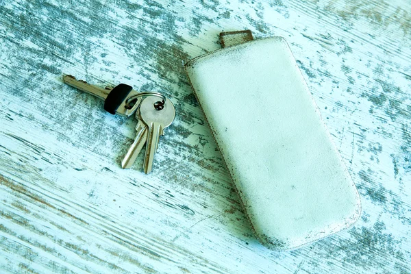 Ключі і смартфон на дерев'яному столі — стокове фото