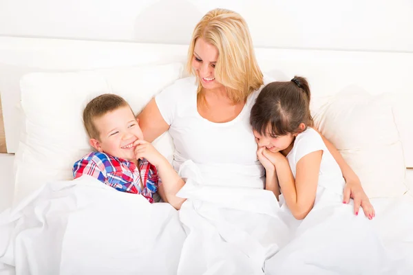 Matka s dcerou a synem v posteli — Stock fotografie