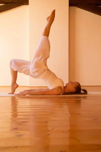 Mujer practicando Yoga en un ático — Foto de Stock