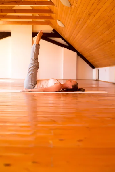 Mulher praticando Yoga em um estúdio — Fotografia de Stock