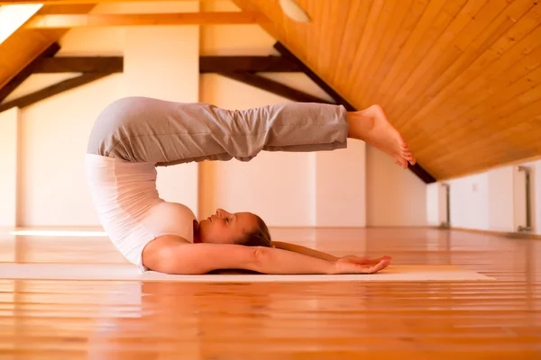 Kvinna som utövar yoga i en studio — Stockfoto