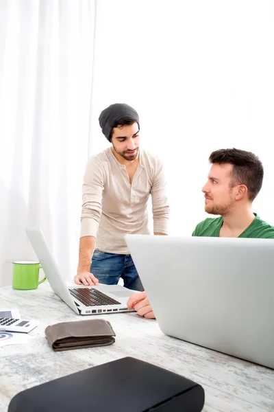 Två medarbetare diskutera något på kontoret — Stockfoto