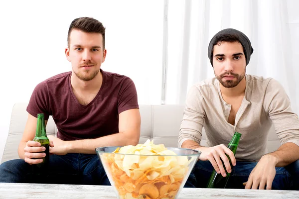 Dos amigos viendo televisión en casa — Foto de Stock