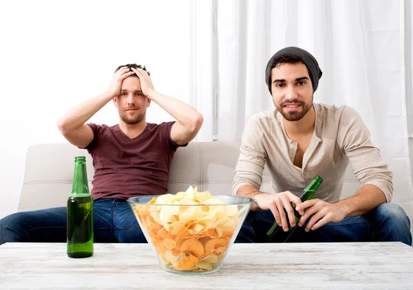 Twee vrienden thuis televisie kijken — Stockfoto