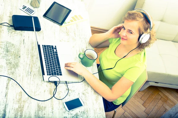 Unga plus size kvinna lyssna på ljud medan du arbetar på en lapt — Stockfoto