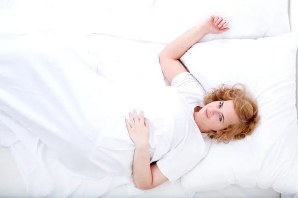 침대에서 쉬고 있는 젊은 여자 — 스톡 사진