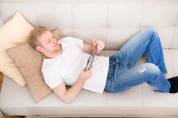 Young man using a tablet at home — Stock Photo, Image