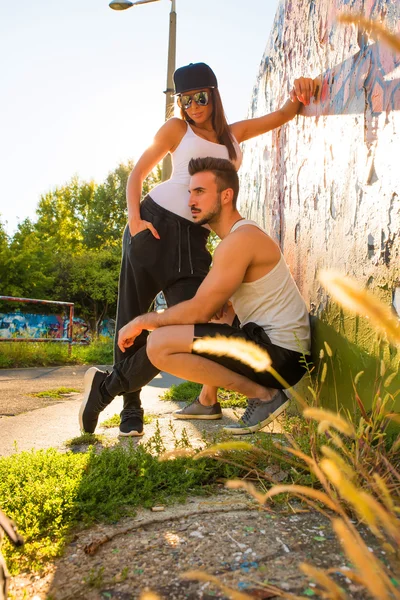 Junges Paar steht an einer Mauer in einer städtischen Umgebung — Stockfoto