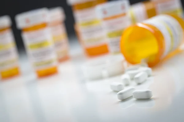 Bottiglie di medicina dietro pillole che fuoriescono dalla bottiglia caduta — Foto Stock