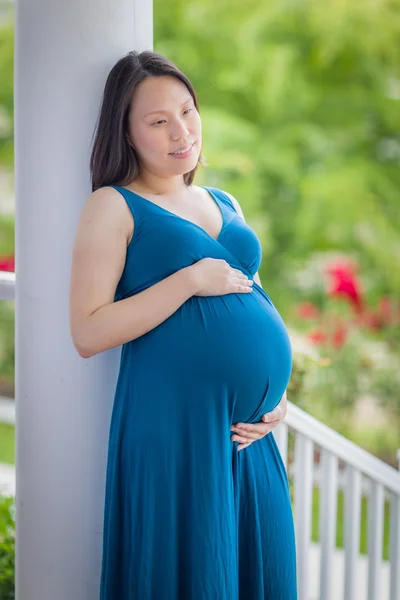 Портрет молодой беременной китаянки на крыльце — стоковое фото