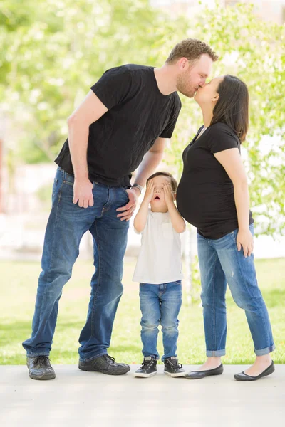 Młody syn ukrywa oczy jak mama w ciąży i Tatuś pocałunek — Zdjęcie stockowe