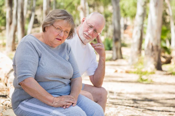 Verärgerte Seniorin sitzt mit besorgtem Ehemann im Freien — Stockfoto