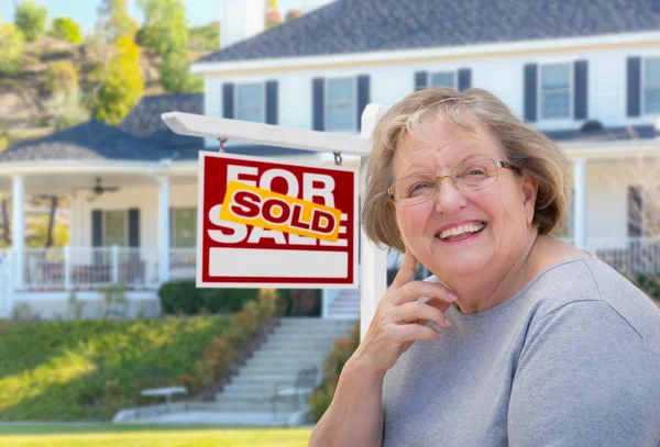 Yetişkin kadın kıdemli Emlak işareti, önünde ev — Stok fotoğraf