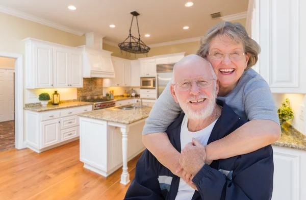 Senior paar umarmt im Inneren benutzerdefinierte Küche — Stockfoto