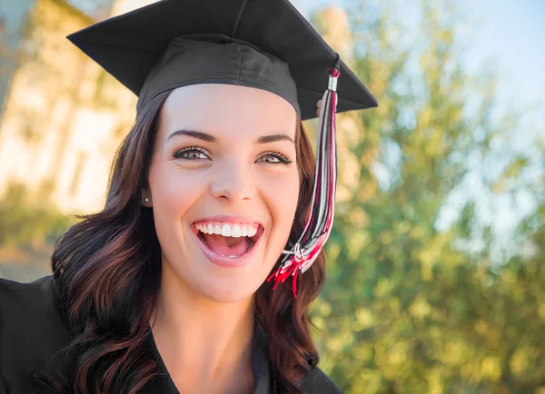 Счастливая выпускница смешанной расы в шапочке и платье — стоковое фото