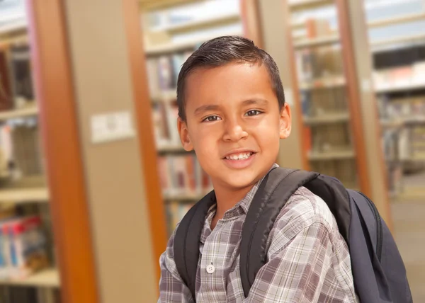 Hispanic Student jongen met rugzak in de bibliotheek — Stockfoto