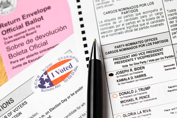 Риверсайд, Калифорния, США - 10 / 2020: Перо, лежащее на Байдене голосовал Официальное голосование, конверт, инструкции и я голосовал наклейка на стол в 2020 Президентские выборы.