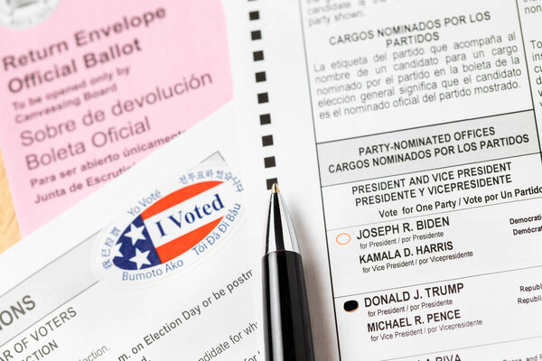 Риверсайд, Калифорния, США - 10 / 2020: Перо, лежащее на Трампе голосовал Официальное голосование, конверт, инструкции и я голосовал наклейка на стол в 2020 году президентских выборов.