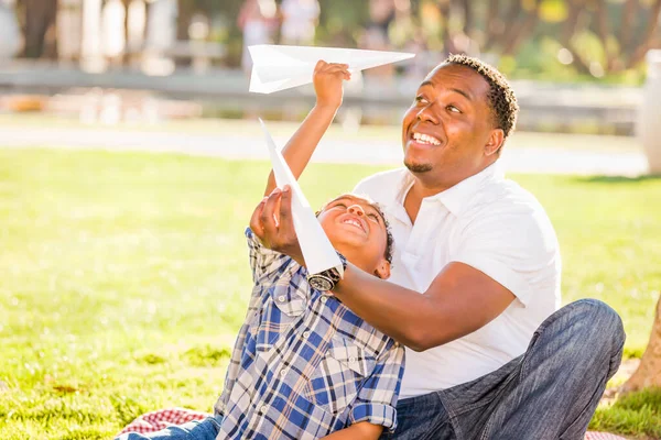 快乐的非裔美国人父亲和混血儿在公园里玩纸飞机 — 图库照片