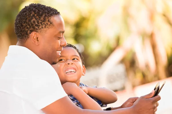 African American Fader Och Mixed Race Son Använda Datorplatta Bänk — Stockfoto