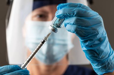 Doktor ya da Hemşire Cerrahi Eldiven Giyen Aşı Şişesi ve Şırınga.