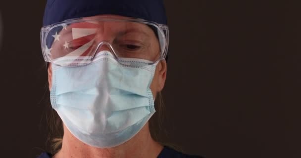 4K医師または看護師は アメリカ国旗反射保持ワクチンバイアルと注射器と医療面マスクとゴーグルを身に着けています — ストック動画