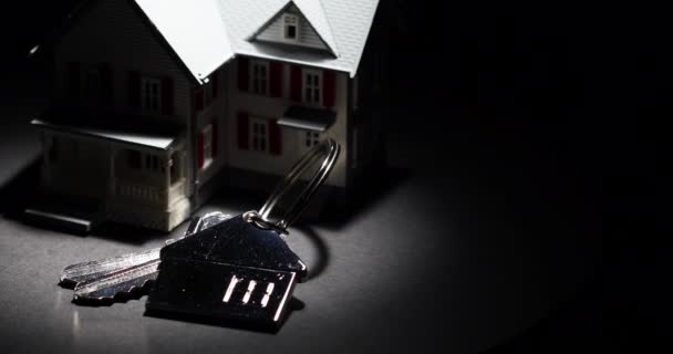 4K点Lit模型的家和键的房子钥匙链慢慢地在黑暗的背景下转动 — 图库视频影像