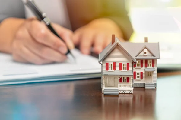 Homem Que Assina Papéis Contrato Imobiliário Com Pequena Casa Modelo — Fotografia de Stock