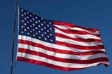 Derin Mavi Gökyüzüne karşı Rüzgarda Dalgalanan Amerikan Bayrağı.